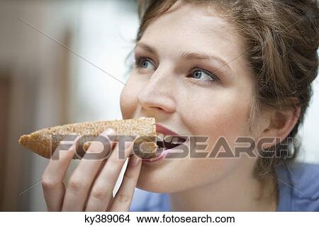 Close-up of a woman eating toast View Large Photo Image Picture - Close-up of a woman eating toast. Fotosearch