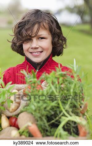 Happy boy with a crate of homegrown vegetables View Large Photo Image Picture - Happy boy with a crate of homegrown vegetables. Fotosearch