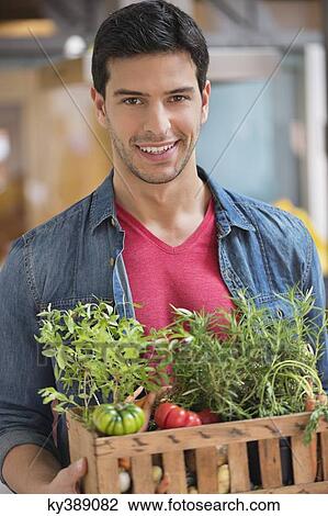 Man carrying fresh vegetables in a crate View Large Photo Image Stock Image - Man carrying fresh vegetables in a crate. Fotosearch