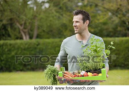 Man holding a tray of raw vegetables View Large Photo Image Stock Photo - Man holding a tray of raw vegetables. Fotosearch