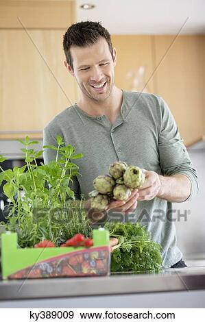 Man preparing food in the kitchen View Large Photo Image Stock Photo - Man preparing food in the kitchen. Fotosearch