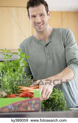 Man preparing food in the kitchen View Large Photo Image Stock Photo - Man preparing food in the kitchen. Fotosearch