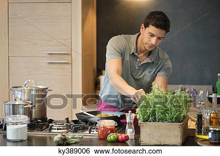 Man preparing food in the kitchen View Large Photo Image Stock Photograph - Man preparing food in the kitchen. Fotosearch