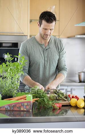 Stock Photograph - Man preparing food in the kitchen. Fotosearch