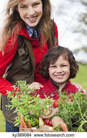 Picture - Mother and son with a crate of homegrown vegetables. Fotosearch