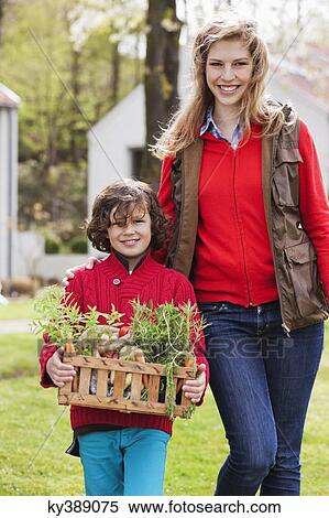 Stock Photography - Mother and son with a crate of homegrown vegetables. Fotosearch