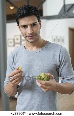 Portrait of a man eating grapes View Large Photo Image Picture - Portrait of a man eating grapes. Fotosearch