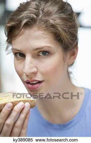 Portrait of a woman eating a bread View Large Photo Image Stock Photography - Portrait of a woman eating a bread. Fotosearch