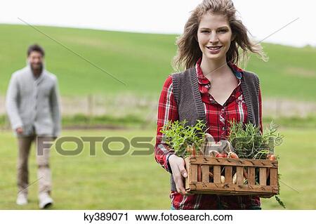 Woman holding a basket of vegetables with her husband in a farm View Large Photo Image Stock Image - Woman holding a basket of vegetables with her husband in a farm. Fotosearch