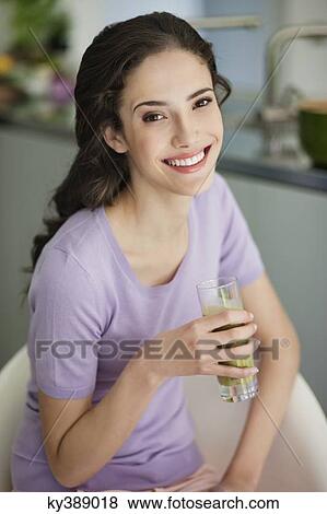 Woman holding a glass of cold soup and smiling View Large Photo Image Stock Photo - Woman holding a glass of cold soup and smiling. Fotosearch