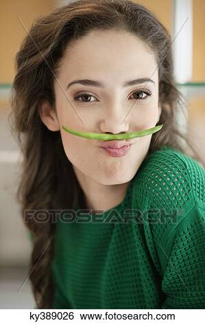 Woman making fun with a French bean View Large Photo Image Stock Photograph - Woman making fun with a French bean. Fotosearch