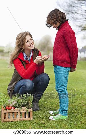 Woman showing vegetables to her son View Large Photo Image Stock Photography - Woman showing vegetables to her son. Fotosearch