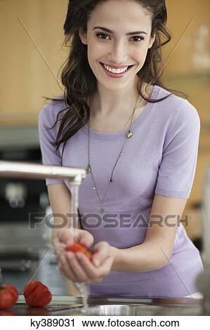 Woman washing tomatoes in the kitchen View Large Photo Image Stock Image - Woman washing tomatoes in the kitchen. Fotosearch