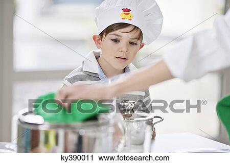 Boy helping his mother at dining table View Large Photo Image Stock Image - Boy helping his mother at dining table. Fotosearch