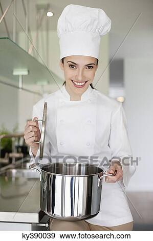 Happy female chef holding a saucepan View Large Photo Image Stock Photo - Happy female chef holding a saucepan. Fotosearch