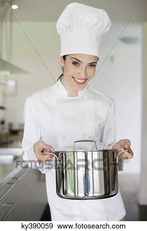 Happy female chef holding a saucepan View Large Photo Image Stock Photo - Happy female chef holding a saucepan. Fotosearch