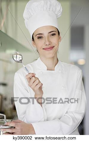 Happy female chef holding a spoon View Large Photo Image Stock Image - Happy female chef holding a spoon. Fotosearch