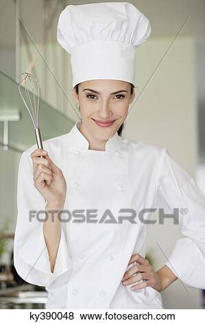 Stock Photo - Happy female chef holding a wire whisk. Fotosearch