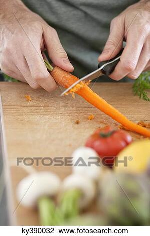 Man cutting carrot View Large Photo Image Stock Image - Man cutting carrot. Fotosearch
