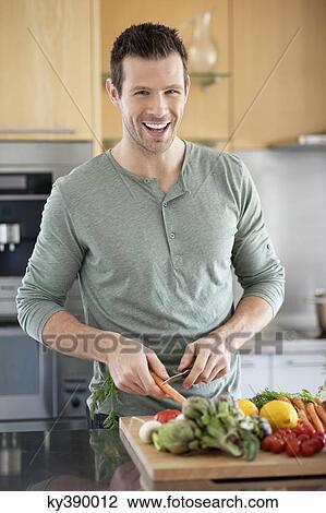 Stock Image - Man preparing food in the kitchen. Fotosearch