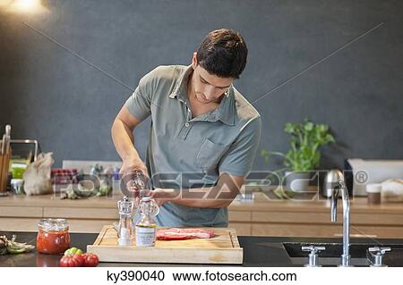 Man sprinkling black pepper on the meat View Large Photo Image Stock Image - Man sprinkling black pepper on the meat. Fotosearch