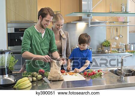 Parents looking at their son cutting vegetables in the kitchen View Large Photo Image Stock Image - Parents looking at their son cutting vegetables in the kitchen. Fotosearch