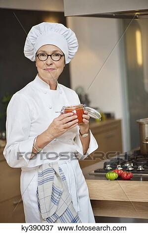 Stock Photo - Woman holding a jar of tomato sauce. Fotosearch