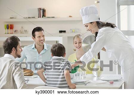 Woman serving lunch at dining table View Large Photo Image Stock Image - Woman serving lunch at dining table. Fotosearch