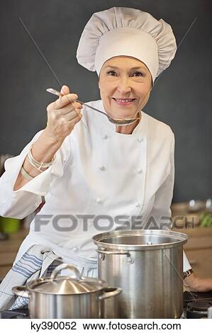 Stock Image - Woman tasting food. Fotosearch