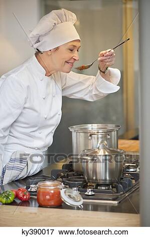 Woman tasting food View Large Photo Image Stock Photo - Woman tasting food. Fotosearch
