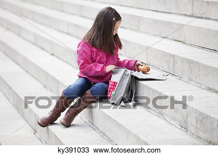 Girl taking out food from her schoolbag View Large Photo Image Stock Image - Girl taking out food from her schoolbag. Fotosearch