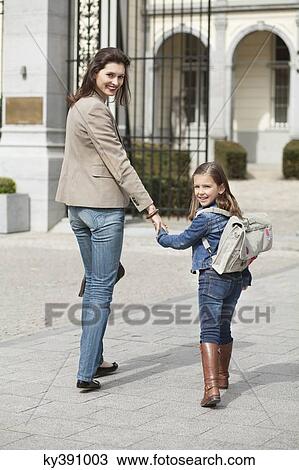 Girl with her mother walking to school View Large Photo Image Stock Image - Girl with her mother walking to school. Fotosearch