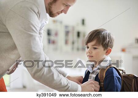 Man preparing his son for school View Large Photo Image Stock Photo - Man preparing his son for school. Fotosearch