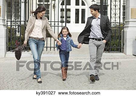 Portrait of a girl walking with her parents View Large Photo Image Stock Photo - Portrait of a girl walking with her parents. Fotosearch