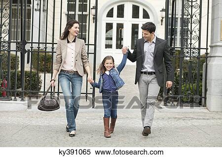 Stock Photography - Portrait of a girl walking with her parents. Fotosearch