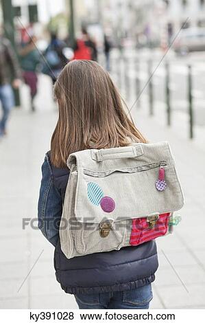 Rear view of a schoolgirl walking on footpath View Large Photo Image Stock Photo - Rear view of a schoolgirl walking on footpath. Fotosearch