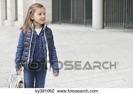Schoolgirl carrying her schoolbag View Large Photo Image Stock Image - Schoolgirl carrying her schoolbag. Fotosearch