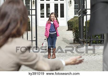 Woman giving warm welcome to her daughter at the school gate View Large Photo Image Stock Photo - Woman giving warm welcome to her daughter at the school gate. Fotosearch