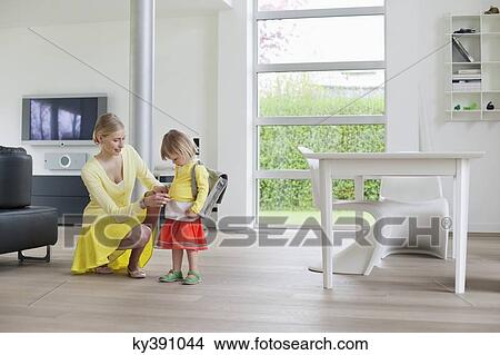 Woman helping her daughter to get ready View Large Photo Image Picture - Woman helping her daughter to get ready. Fotosearch