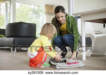 Stock Photo - Woman helping her daughter to get ready for school. Fotosearch