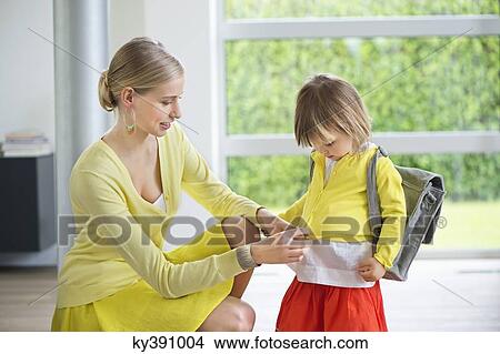 Woman preparing her daughter for school View Large Photo Image Picture - Woman preparing her daughter for school. Fotosearch
