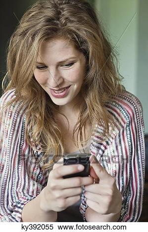 Close-up of a beautiful woman text messaging on a mobile phone View Large Photo Image Stock Photography - Close-up of a beautiful woman text messaging on a mobile phone. Fotosearch
