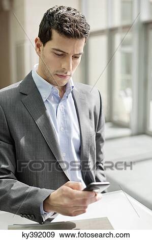 Stock Photo - Close-up of a businessman text messaging. Fotosearch