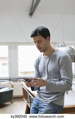 Man leaning against a pool table using a mobile phone View Large Photo Image Stock Photography - Man leaning against a pool table using a mobile phone. Fotosearch