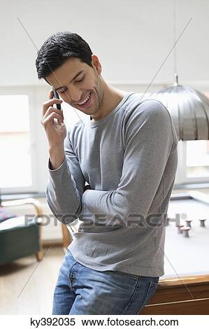 Man leaning against a pool table while talking on a mobile phone View Large Photo Image Stock Photography - Man leaning against a pool table while talking on a mobile phone. Fotosearch
