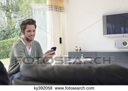 Man reading a text message on mobile phone View Large Photo Image Stock Photo - Man reading a text message on mobile phone. Fotosearch