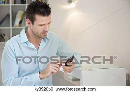 Stock Image - Man using a mobile phone. Fotosearch