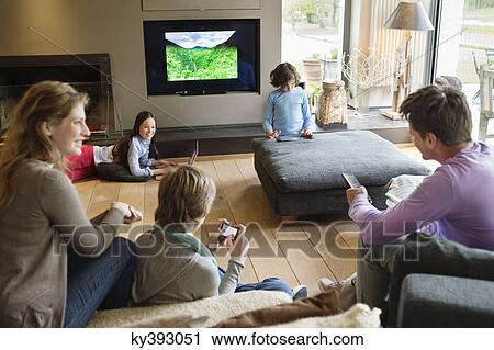 Family using electronic gadgets in a living room View Large Photo Image Stock Image - Family using electronic gadgets in a living room. Fotosearch