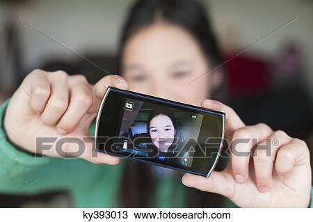 Girl taking picture of herself with a mobile phone View Large Photo Image Stock Image - Girl taking picture of herself with a mobile phone. Fotosearch