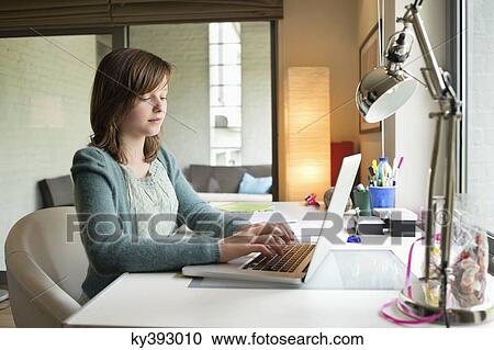 Girl using a laptop at home View Large Photo Image Stock Image - Girl using a laptop at home. Fotosearch